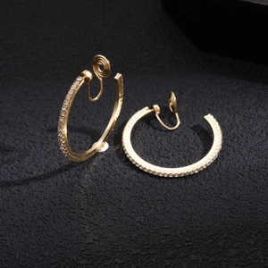 Macro shot of gold-plated hoop clip-on earrings featuring paved crystals and spring closure