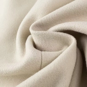 Gros plan sur la texture du tissu en laine crème avec sensation laine et cachemire
