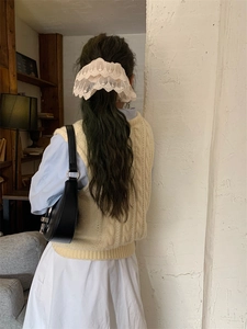 Detailed view of an elegant beige lace scrunchie worn in a vintage French style hair look