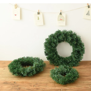 Trois tailles de couronnes de Noël vertes présentées sur une surface en bois rustique