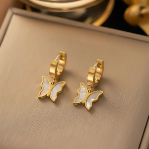 Detailed close-up of golden butterfly earrings featuring white mother-of-pearl inlay