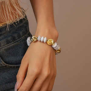 Detailed shot of irregular acrylic beads bracelet with marble patterns and golden finish