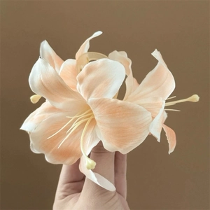 Handheld variant of the large lily flower hair clip in orange and peach gradient