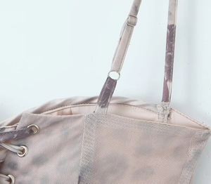 Detailed view of tie-dye mesh fabric with adjustable straps and metal eyelet buckles