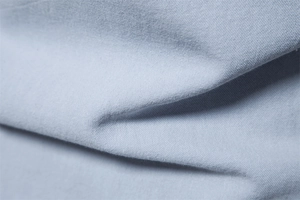 Macro detail of high-quality light blue-grey cotton fabric with soft plain weave texture