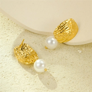 Square hammered 18K gold earrings with freshwater pearls on a natural stone base