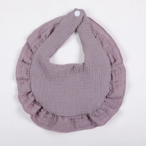 Detail of ruffle cotton gauze baby bib with breathable muslin texture and white snap button