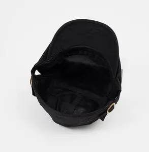 Detail of the black duckbill cap interior with breathable mesh lining and metal buckle
