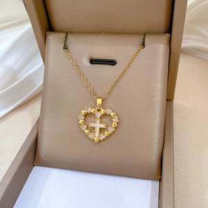 Detail of gold heart cross necklace with crystals in premium jewelry gift box