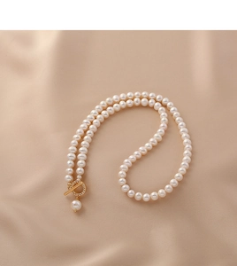Detail of natural freshwater pearl necklace with a gold crystal-encrusted OT clasp on silk