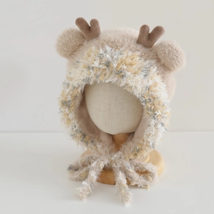 Close-up of soft faux mink fur kids hat featuring cute brown reindeer antlers and earflaps