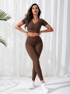 Detail of dark brown ribbed seamless yoga set showing V-neck crop top and high waist leggings