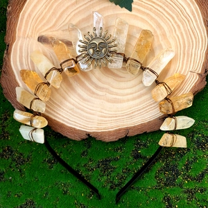 Detail of handmade yellow crystal crown headband with sun emblem on wood slice