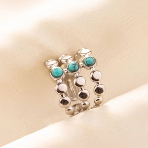 Detailed macro view of triple-row silver ring with turquoise stones and beaded texture