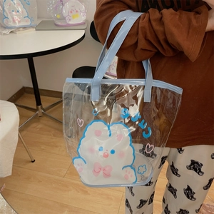 Détail d'un sac cabas transparent en PVC avec anses bleu clair et motifs de dessins animés