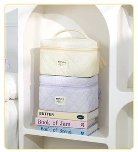 Quilted cosmetic bags in beige and lavender featuring elegant diamond stitch and handles