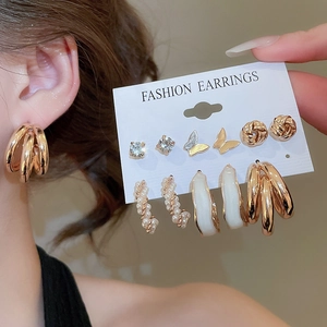 Detail of 6-pair gold earring set featuring butterfly, pearl, and rhinestone designs
