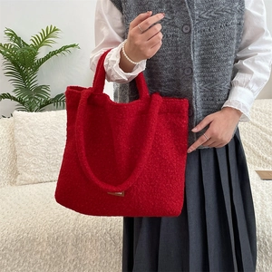 Dettaglio della borsa tote rossa in tessuto boucle con logo in pelle marrone
