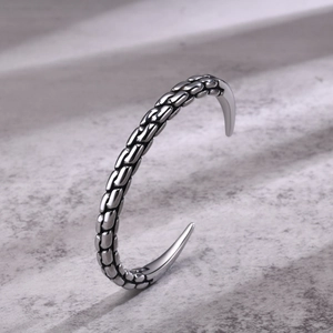 Detailed close-up of men's silver open cuff bracelet featuring an intricate braided texture