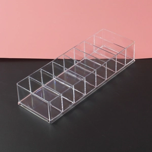 Close-up of a clear acrylic lipstick organizer with 8 slots on a black surface