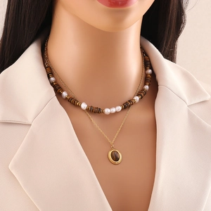 Double-layered tiger stone bead necklace with a gold chain and heart pendant