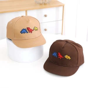 Close-up of kids dinosaur embroidery on khaki and dark brown cotton baseball caps