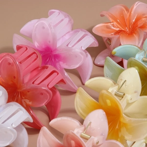 Detailed close-up of colorful resin plumeria hair claws showing flower shape and spring