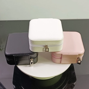 Three compact square jewelry organizers in black, white and pink with zip closure