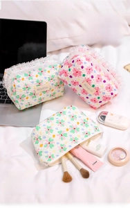 Floral quilted cosmetic bags with white lace trim for skincare and makeup storage