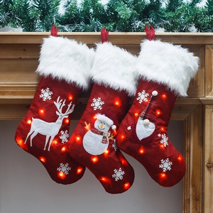 Three LED lighted Christmas stockings with Reindeer, Snowman, and Santa embroidery patterns