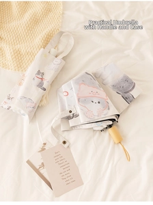 Close-up of portable umbrella set with cute cat patterns and wooden handle