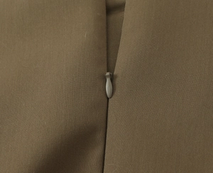 Detailed close-up of a seamless invisible zipper on a slim-fit double-breasted top