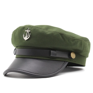 Dettaglio del cappello da marinaio verde oliva con visiera in pelle nera e ancora d'argento