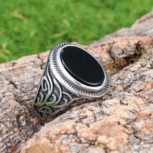 Vintage silver mens ring with black oval stone and floral engraving on wood