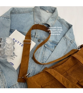 Detail of adjustable long shoulder strap and brown corduroy fabric on a tote bag