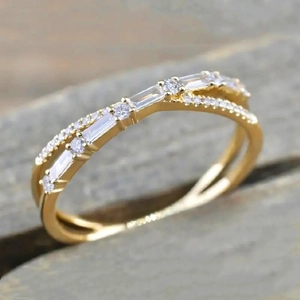 Minimalist double-row criss-cross gold ring with baguette and round micro-pave diamonds