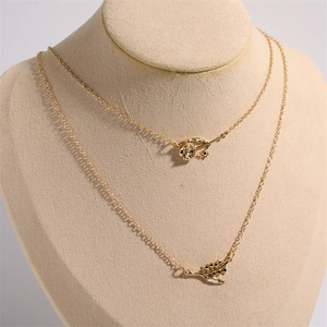 18K gold-plated double-layer necklace with rose and leaf pendants on a beige bust mannequin