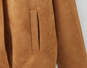 Macro view of detailed welt pocket stitching on a high-quality brown suede jacket