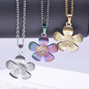 Three stainless steel flower necklaces in silver, gold and rainbow finish on a black display
