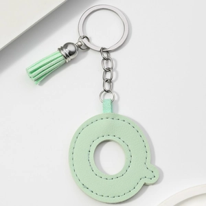 Detail of light green PU leather letter Q keychain with matching tassel and silver ring