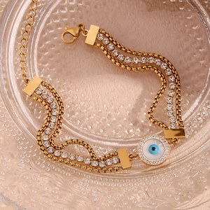 Detailed view of 18K gold-plated triple-layer chain bracelet with evil eye and zircons