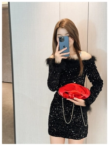 Chic red metallic clutch bag with gold chain paired with a black sequin feather dress
