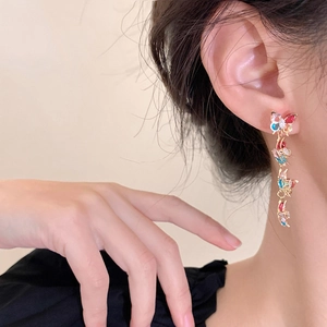 Detail of colorful butterfly drop earrings with cubic zirconia and long metal tassels