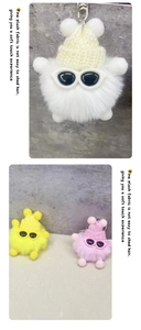 Gros plan de porte-clés monstre en peluche blanc, jaune et rose avec lunettes de soleil