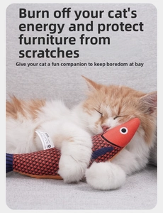 Close-up of a lifelike plush fish cat toy with a cozy cat sleeping beside it