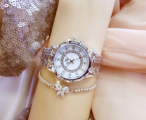 Close-up of silver rhinestone ladies watch with floral mother-of-pearl dial on a model wrist