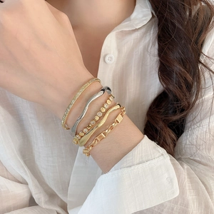 Close-up of stacked 18k gold plated bracelets with geometric zircon honeycomb details