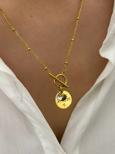 Detail of gold OT toggle necklace with zircon pendant and My Kids engraved disc