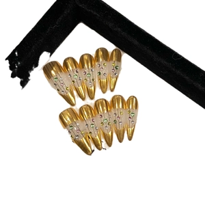 Handmade stiletto press-on nails in gold metallic finish with colorful crystal accents