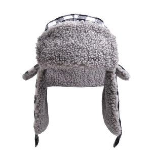 Detail of winter trapper hat showing black and white plaid pattern and warm faux fur lining